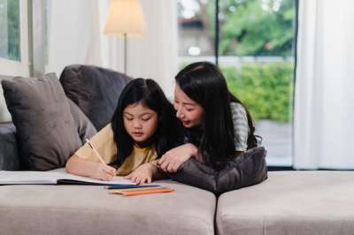 mother helps her daughter doing homework woman and girl doing homework