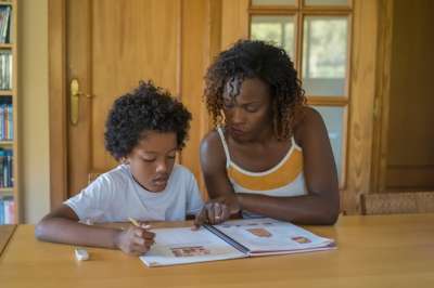 african teacher tutoring an african boy boy and a teacher doing a task