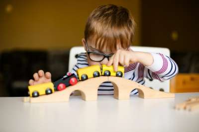 boy playing with a wooden train boy playing