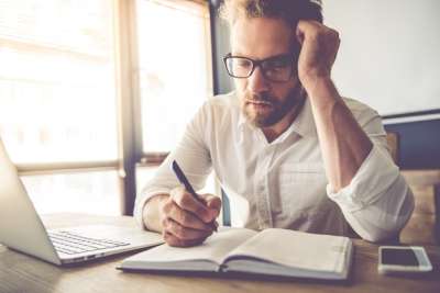 male teacher is writing a lesson plan in his notebook male teacher is preparing for the lesson