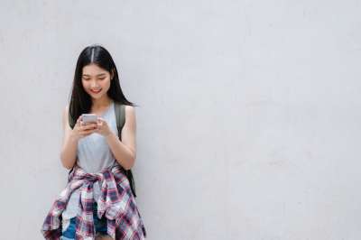 japanese woman by the wall with a cell phone japanese woman