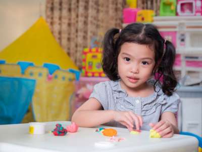 cute little girl at the table playing with play dough girl playing with play dough