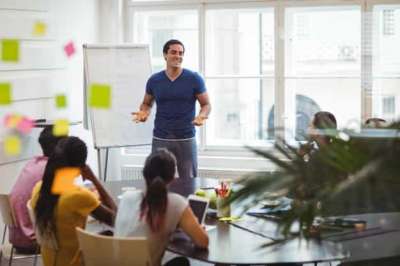 adult esl class teacher in front of students