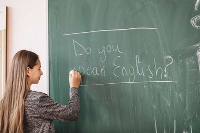 teacher writing on a blackboard