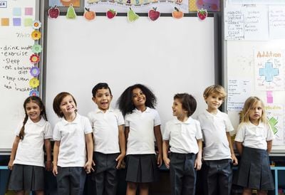 a group of children standing by the whiteboard