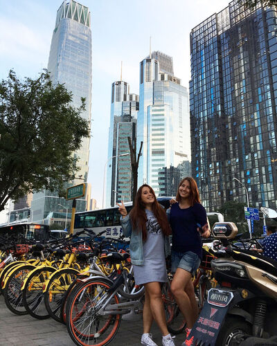 two pretty girls and a skyscraper on the background