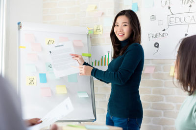 asian teacher in front of board