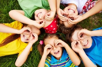 kindergarten kids playing on the green grass