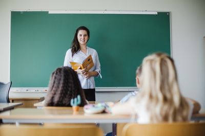 teacher standing in front of the students