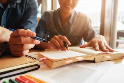 man and woman with books and notebooks