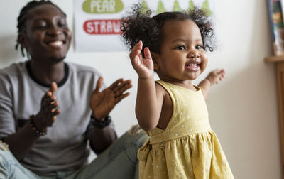 african teacher playing with a happy girl