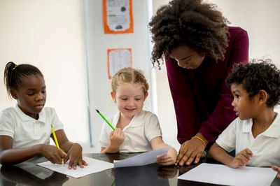 african teacher and elementary school students