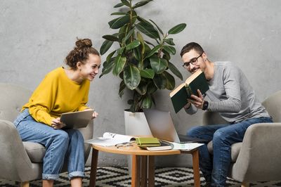 woman and man sitting in front of each other with books