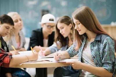 students at the desk writing