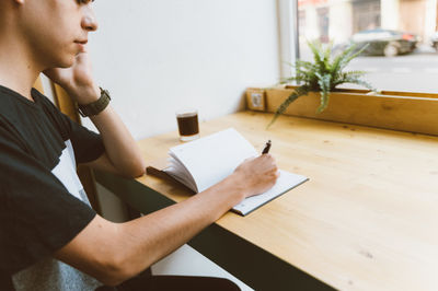 man writing in the notebook